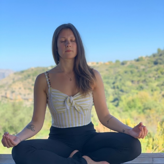 mujer meditando en solterreno en la casa de madera